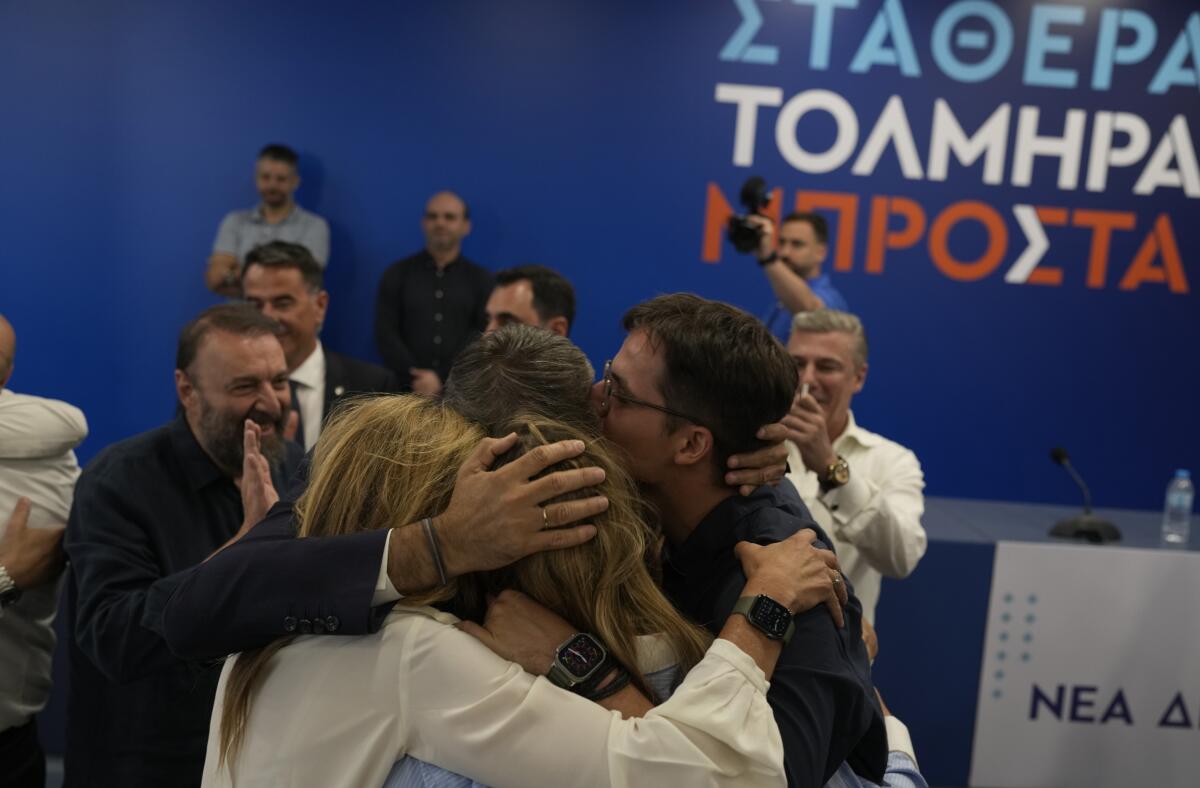 Kyriakos Mitsotakis hugs his family after his party's election win.