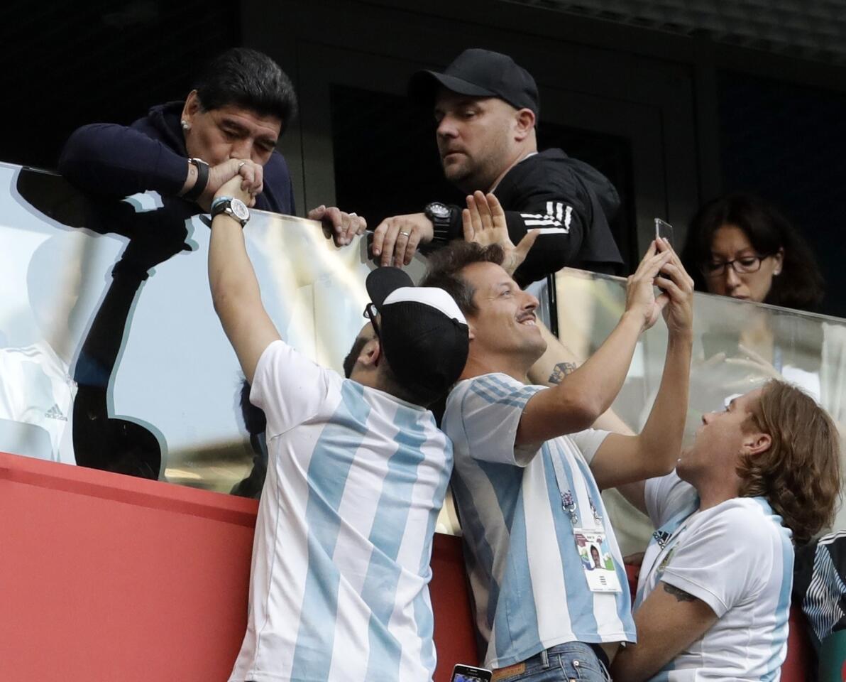 Argentina former soccer star Diego Maradona kisses the hand of a soccer fan ahead of the group D match between Argentina and Nigeria, at the 2018 soccer World Cup in the St. Petersburg Stadium in St. Petersburg, Russia, Tuesday, June 26, 2018. (AP Photo/Petr David Josek)