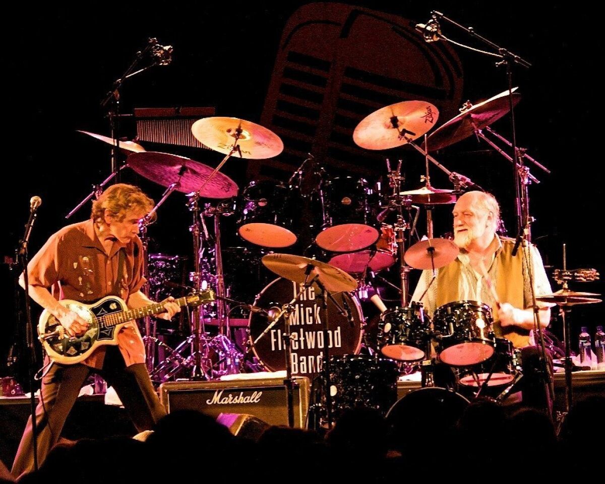 Guitarist Rick Vito and drummer Mick Fleetwood are shown in concert. 