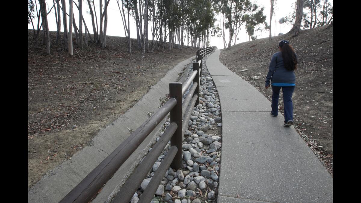 A woman walks from the community center up toward the Bowl Loop. The bowl at the park was formed by a dam disaster in 1963.