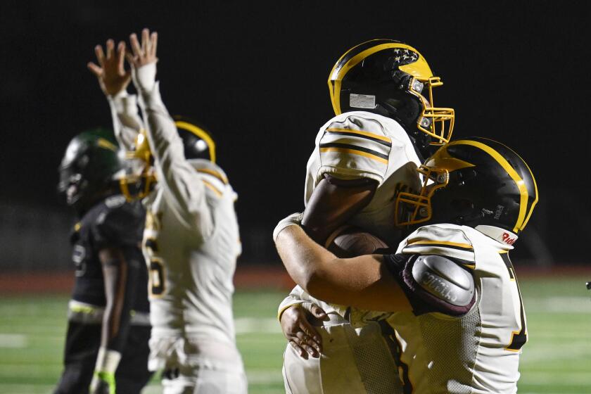 Mission BayOs Ricky Esquer (13), center, is congratulated by Kai West (78), right, after Esquer scored a touchdown in overtime against Patrick Henry during a high school football game September, 29, 2023 in San Diego. Mission Bay won 41-35 in overtime. (Photo by Denis Poroy)