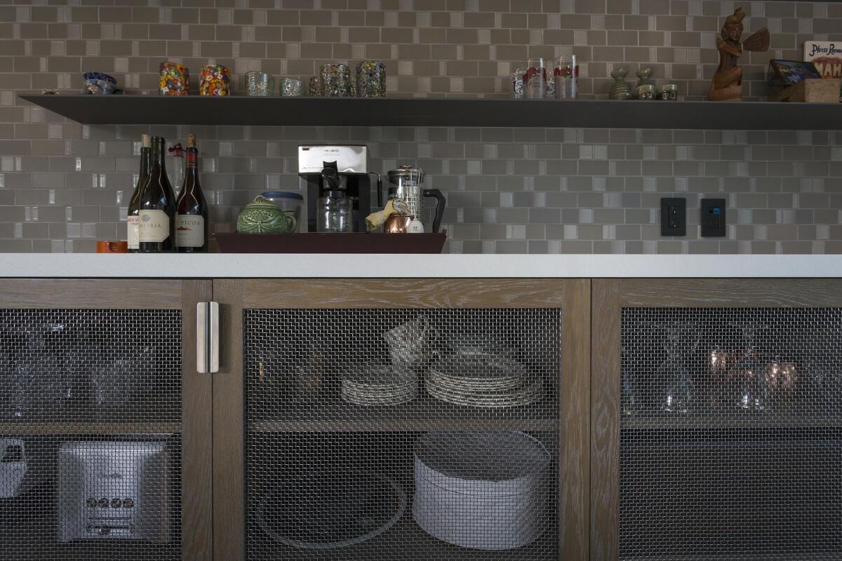 Pig wire serves as screens for kitchen shelves at the house of Jenn McCabe, her partner Lee Frees, and their dog Hank.