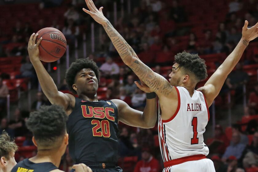 USC guard Ethan Anderson (20) goes to the basket as Utah forward Timmy Allen (1) defends in the first half of an NCAA college basketball game Sunday, Feb. 23, 2020, in Salt Lake City. (AP Photo/Rick Bowmer)