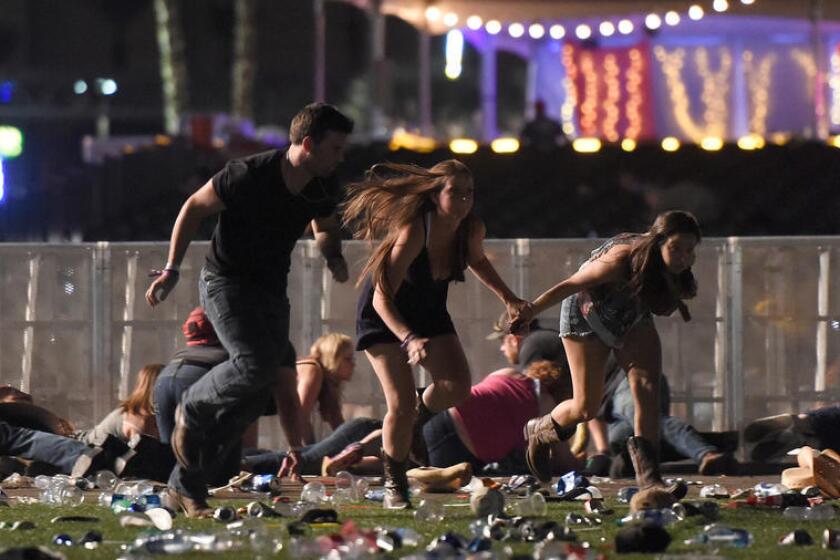 People run from the Route 91 Harvest country music festival after hearing gunfire Sunday night in Las Vegas. The shooter was firing from the nearby Mandalay Bay Resort and Casino.