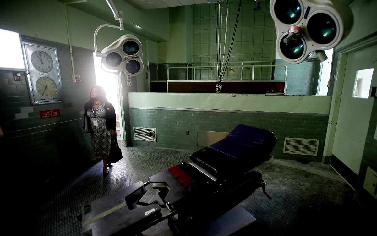 A visitor looks around an operating room at Los Angeles County General Hospital.
