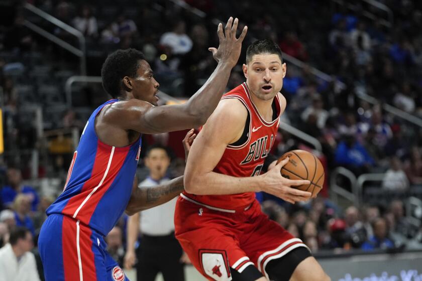 Nikola Vucevic, pívot de los Bulls de Chicago, trata de avanzar ante Jalen Duren, de los Pistons de Detroit, en el duelo del jueves 11 de abril de 2024 (AP Foto/Paul Sancya)