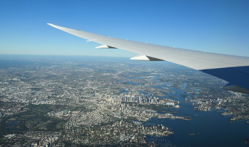 An aerial view of New York City and the aircraft's left wing taken from the plane after takeoff.