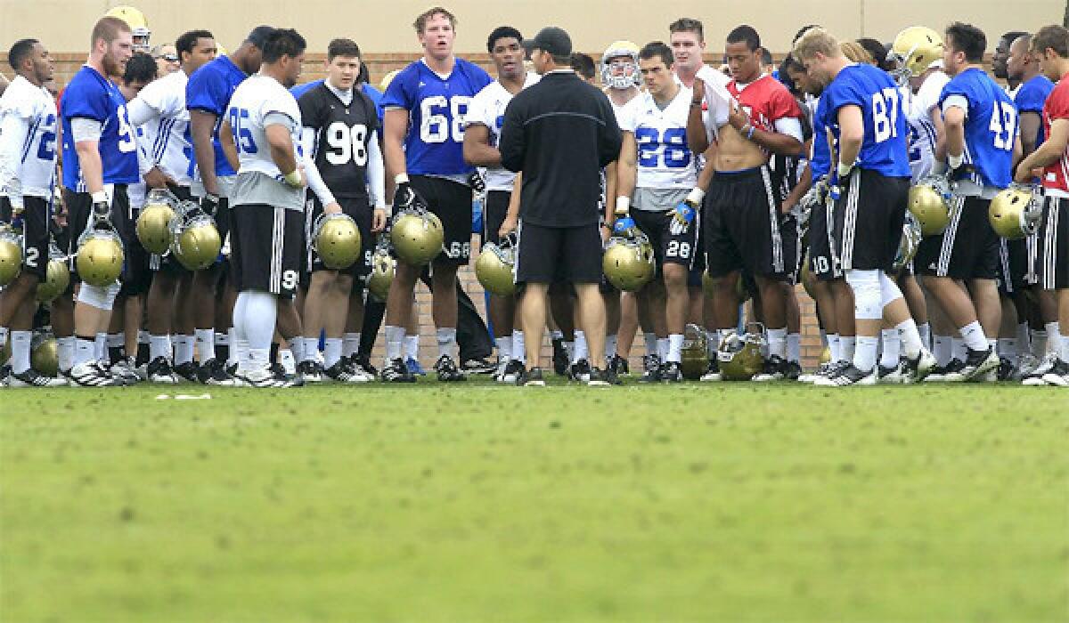 UCLA football Coach Jim Mora talks with his Bruin players after practice on April 2, 2013.