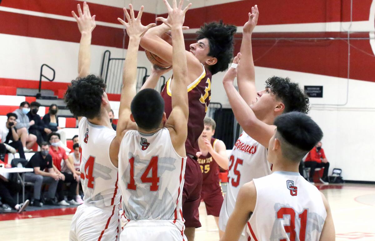 Ramon Lopez (33) of Ocean View High School is surrounded by Garden Grove defenders during a league game in January.