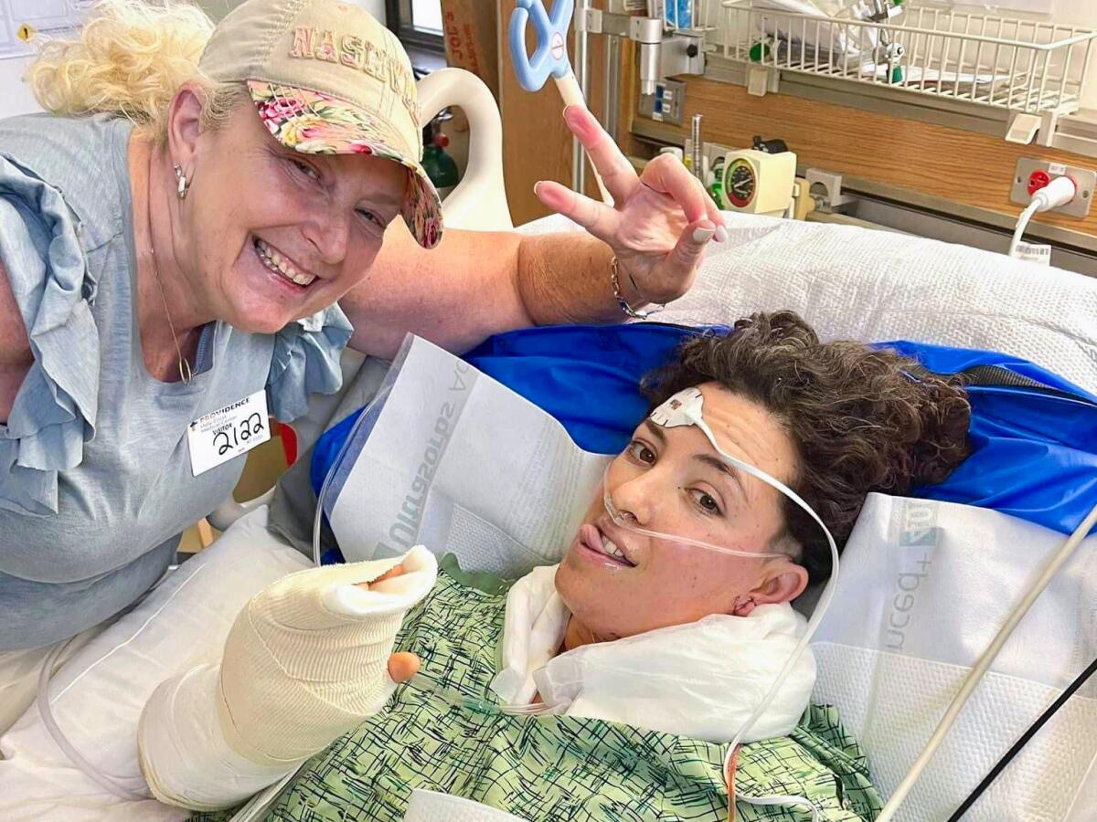  Allie Shehorn in a hospital bed, with Christine White standing nearby.