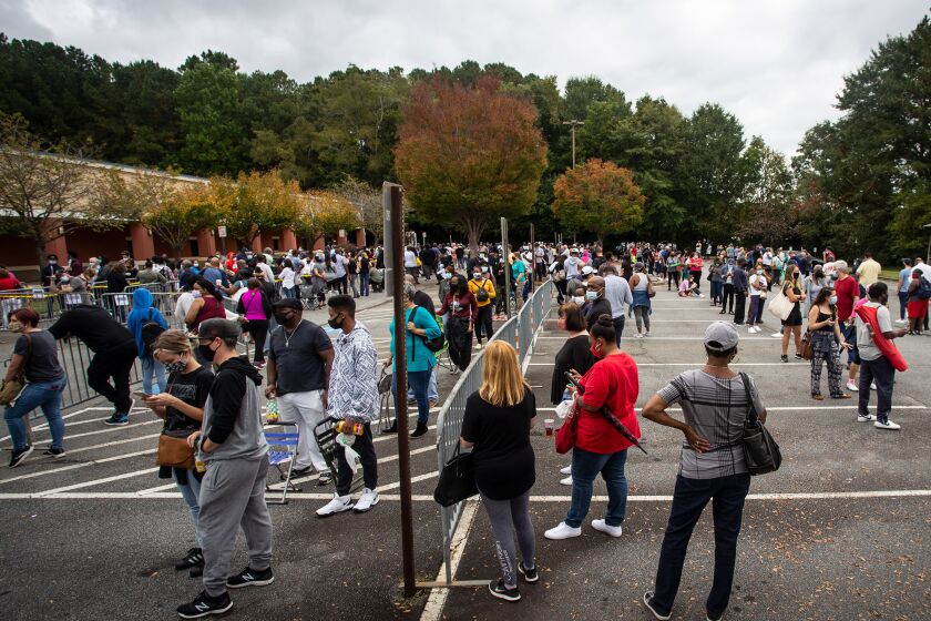 Hundreds of people wait in line for early voting in Marietta, Georgia, Monday, Oct. 12, 2020. (AP Photo/Ron Harris, File)