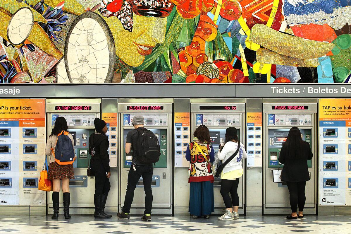 Metro passengers add fares to their ticket cards at the Universal City Red Line station. A proposal that the Metro board will consider Thursday could raise fares as much as 117% over the next eight years.