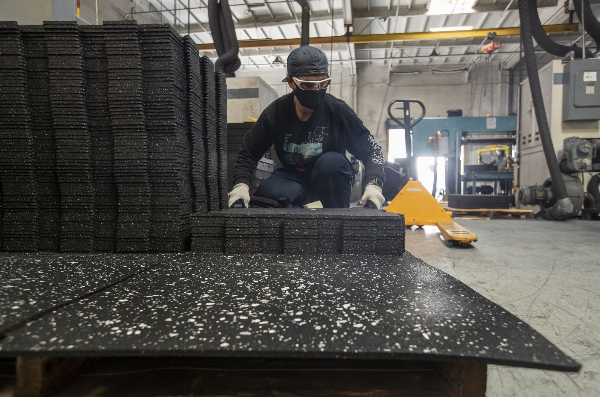 Alisha Kerichenko, 45, stacks rubber tiles after dye cutting them at U.S. Rubber Recycling in Colton. 