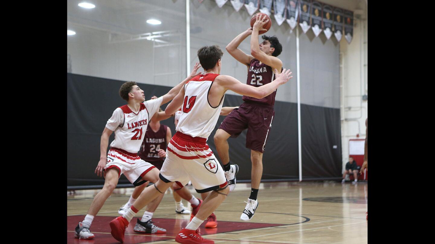 Laguna's Blake Burzell puts up a shot in front of Orange Lutheran defenders in the Charlie Wilkins Memorial Tournament at Westminster High on Tuesday.