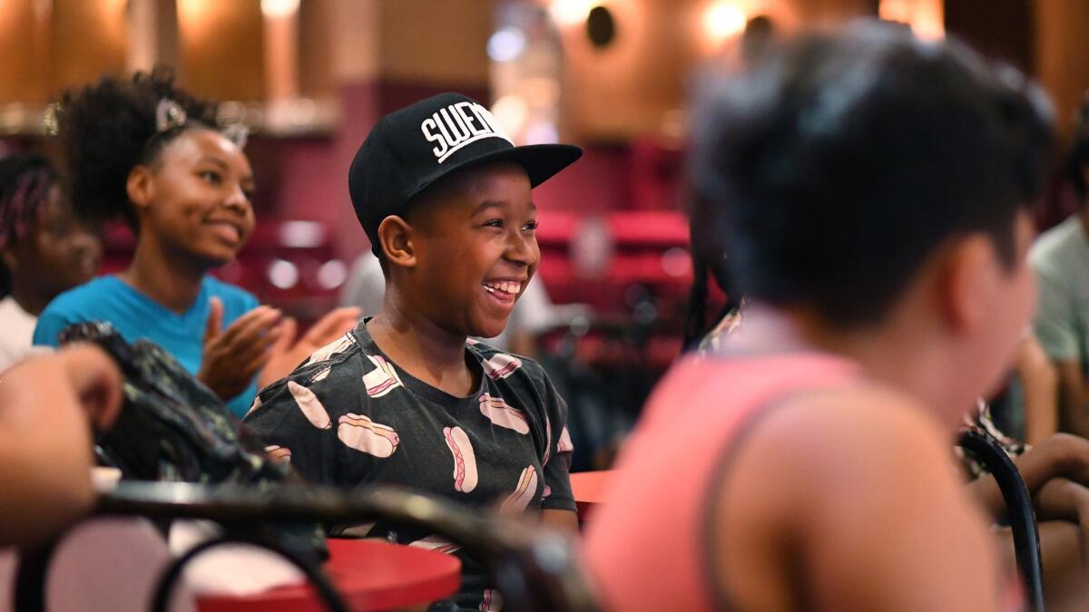 Anthony Torrence, center, laughs along with his fellow Comedy Camp attendees at the Laugh Factory in Los Angeles.