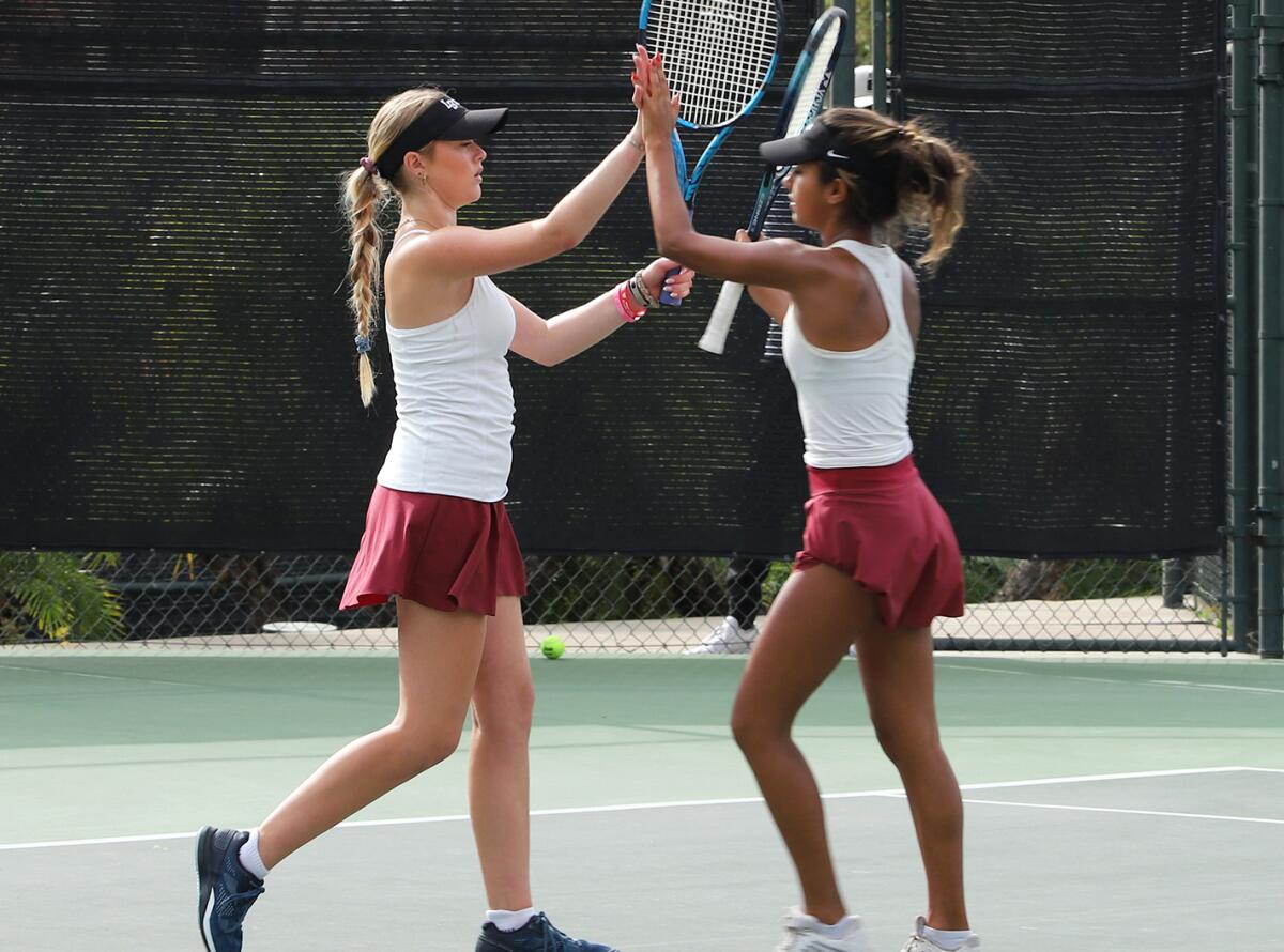 Laguna Beach's doubles team of Ryan Levine, left, and Ava Chadha high-five after winning their set against Calabasas.