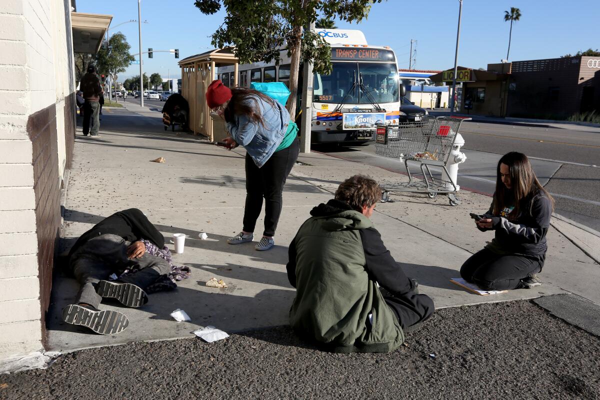 City Net volunteer and licensed vocational nurse Angie Munoz, left, and Jennifer Munoz, right, speak with homeless men.