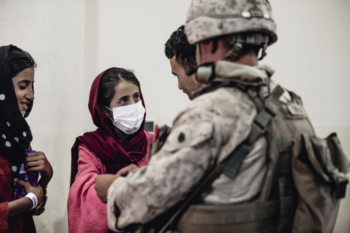 In this image provided by the U.S. Marine Corps, a Marine processes youth to be evacuated.