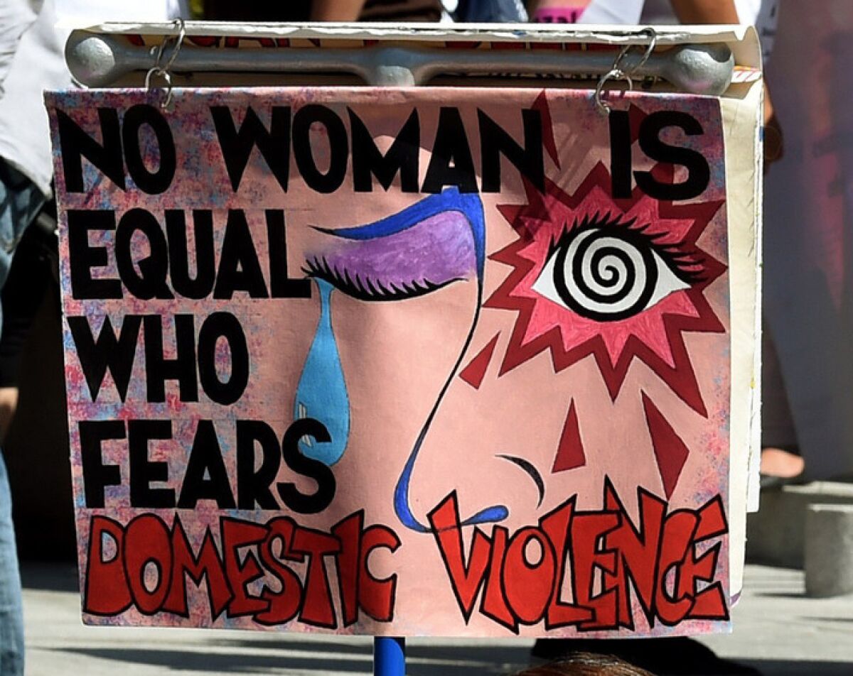 A sign at a rally in 2015 reads "No woman is equal who fears domestic violence"