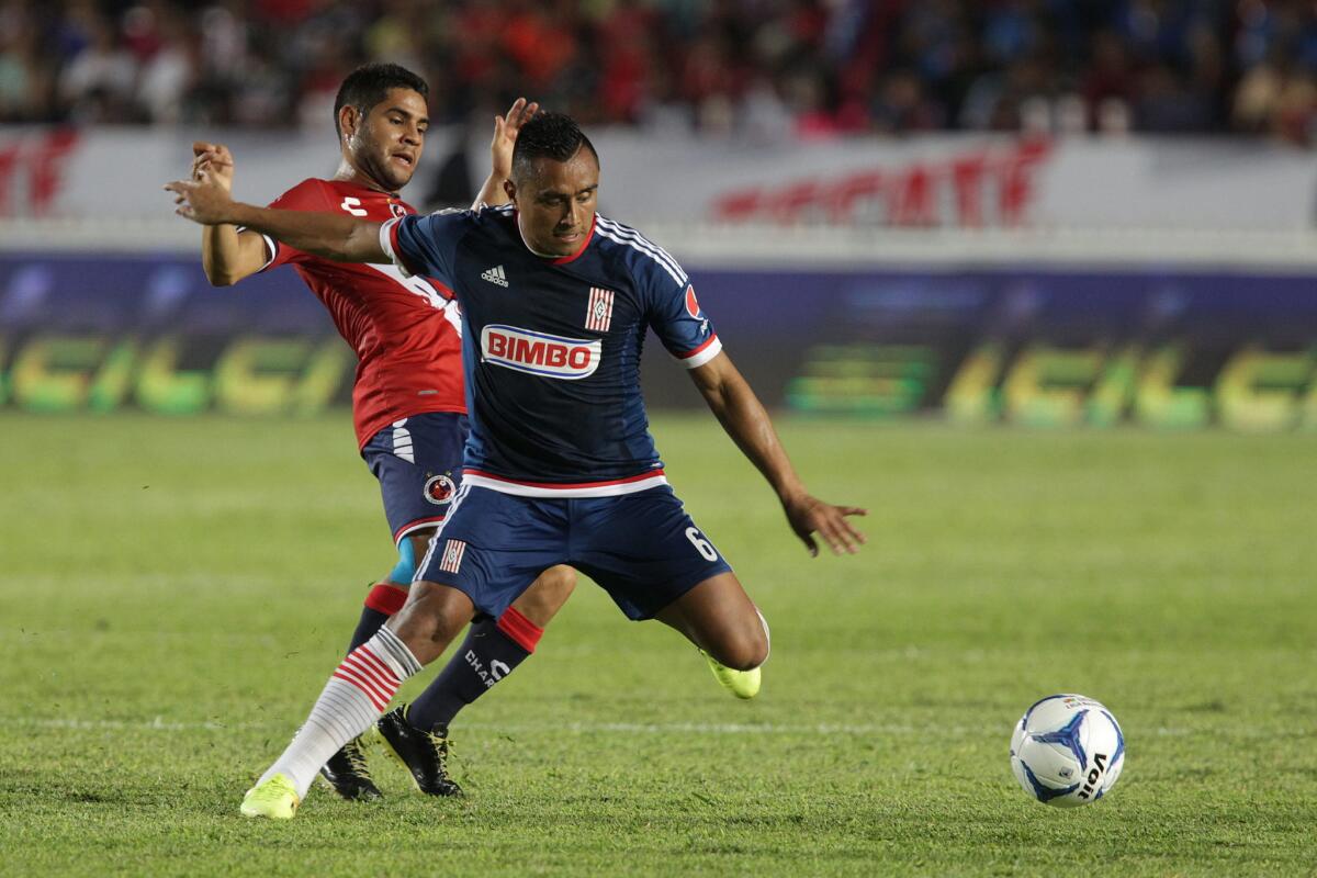 Daniel Villalba (i) de Tiburones del Veracruz disputa el balón con Edwin Hernández (d) de Chivas del Guadalajara.
