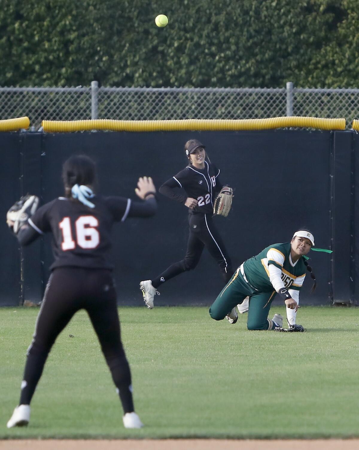 Edison's Jaelyn Operana, right, throws the ball to Huntington Beach's Megan Ryono, left, to start a triple play in the first inning of the Orange County Softball Coaches All-Star Classic on Tuesday. She made a diving catch as Huntington Beach's Jadelyn Allchin, center, looked on.