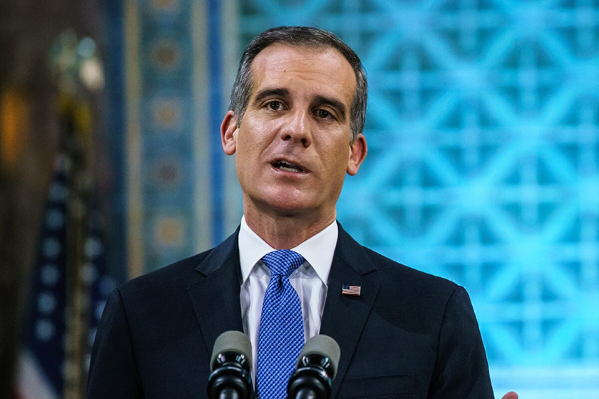 Los Angeles Mayor Eric Garcetti speaks at a microphone.