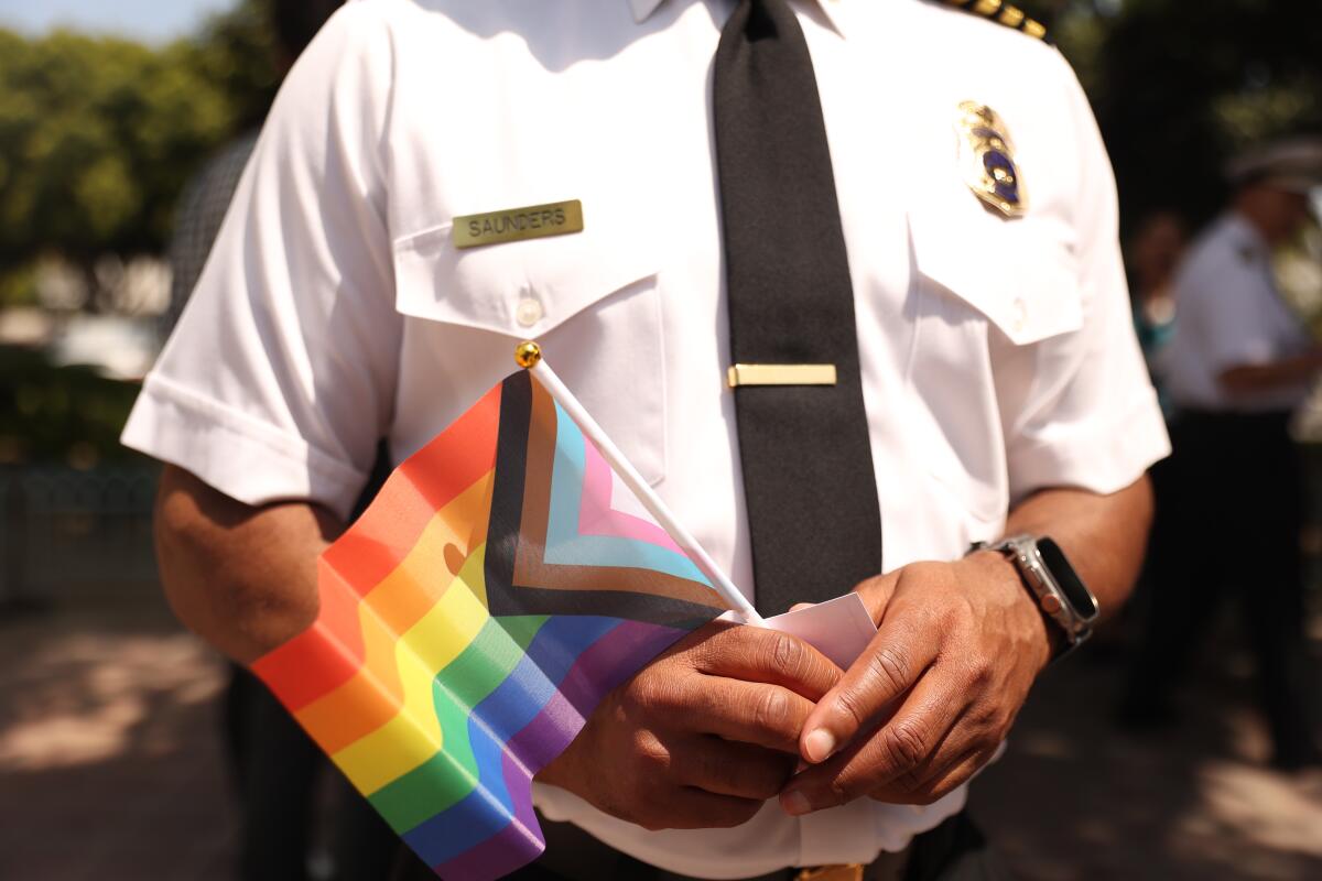 An LAFD official holds a small Pride flag.