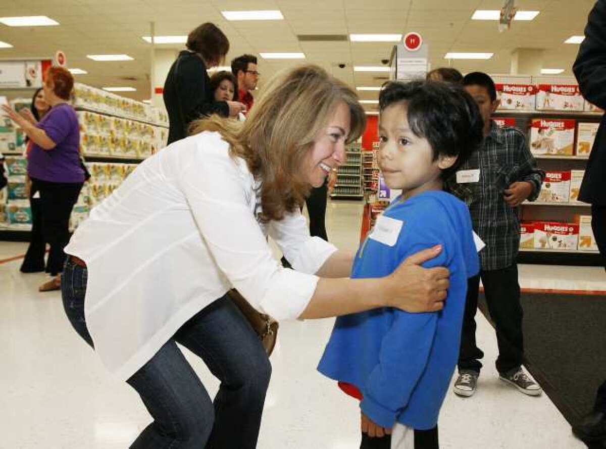 Hilda Morovati, of Toluca Lake, introduces herself to Christian Vargas, 5, at Target in Glendale where about 30 local children matched up with volunteers holding $80 gift cards to shop for school supplies and clothing.
