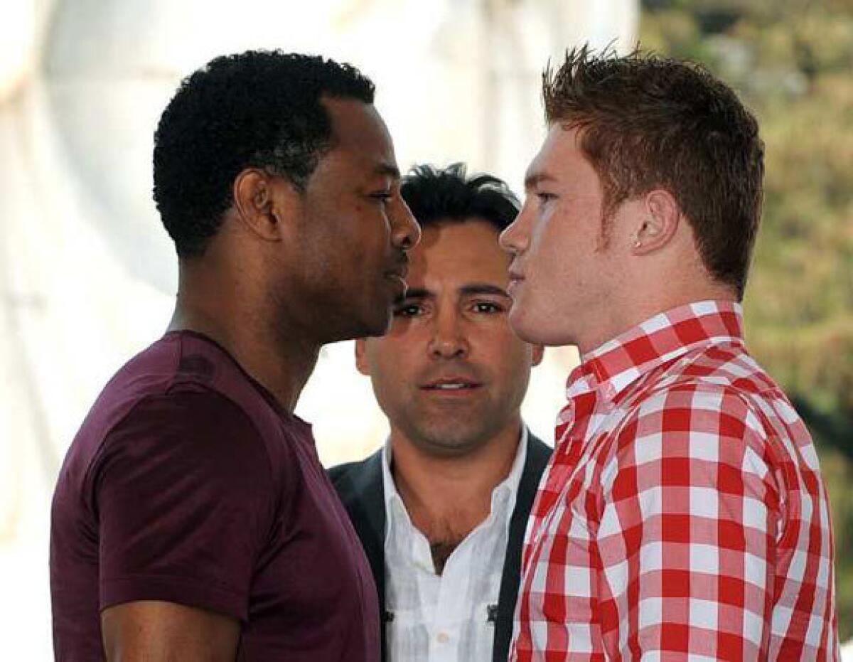 With boxing legend Oscar De La Hoya looking on, Shane Mosley, left, and Saul "Canelo" Alvarez face off in a pre-fight staredown at a Wednesday news conference at the MGM Grand in Las Vegas.