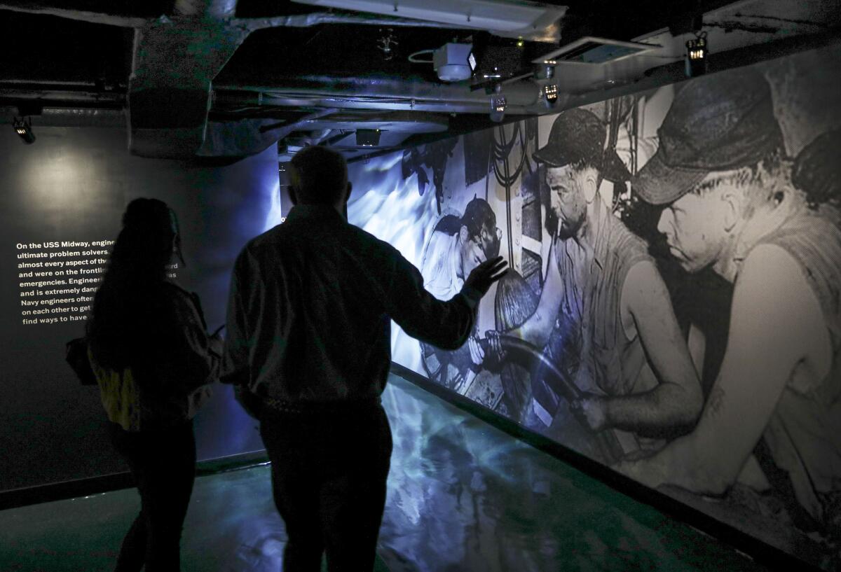 Guests walk through the USS Midway's new exhibit "Midway's Engineers: Service, Sacrifice and Everyday Life"