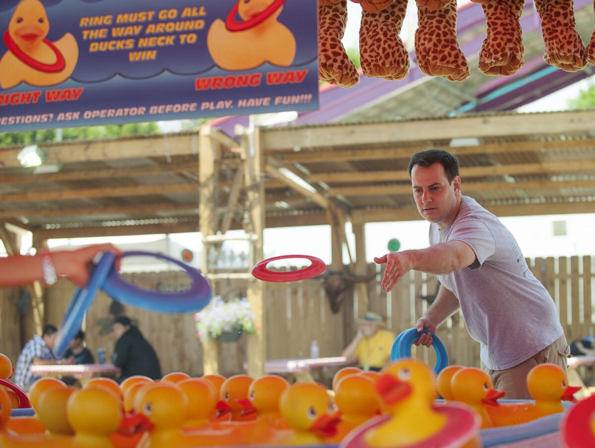 Brad Zint plays Ring A Duck, a carnival game at the Orange County Fair on Wednesday.