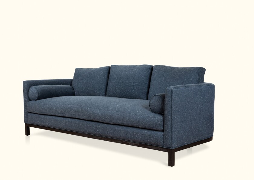 The Curved Back sofa from Lawson-Fenning features a single down-wrapped cushion with a trio of removable back cushions.