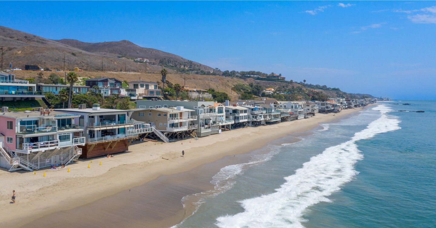 The architectural beach house expands to two levels of wood decks overlooking the ocean.