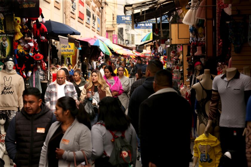LOS ANGELES, CA - DECEMBER 6, 2022 - - Shoppers, some wearing masks, some not, make their way along Santee Alley in Los Angeles on December 6, 2022. Los Angeles County appears in the midst of another full-blown coronavirus surge, with cases rising by 75% over the last week. The spike - which partially captures but likely does not fully reflect exposures over the Thanksgiving holiday - is prompting increasingly urgent calls for residents to get up to date on their vaccines and consider taking other preventative steps to stymie viral transmission and severe illness. (Genaro Molina / Los Angeles Times)