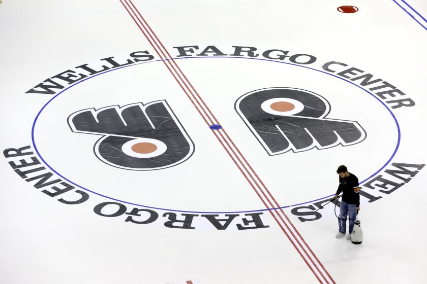 A worker prepares the ice at Wells Fargo Center on Monday for the 2013-14 Philadelphia Flyers season.