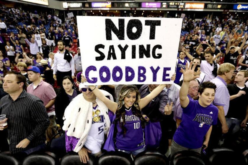 A Sacramento Kings fan holds up a sign expressing her hopes that the team won't move.