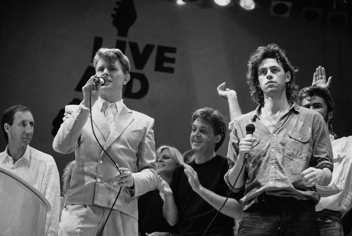 Two men hold microphones on the Live Aid concert stage