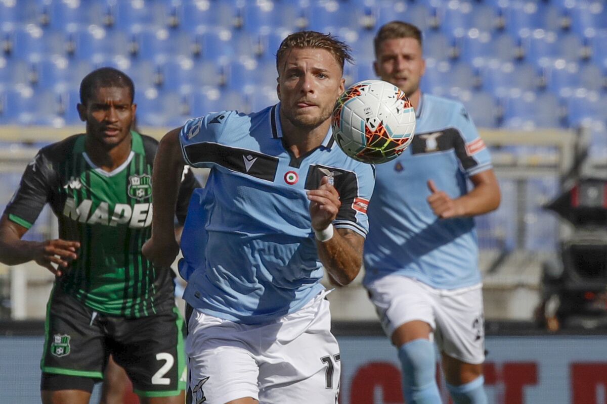 FILE - In this Saturday, July 11, 2020 file photo, Lazio's Ciro Immobile eyes the ball during the Serie A soccer match between Lazio and Sassuolo at the Rome Olympic Stadium. Prolific scorer Ciro Immobile has extended his contract with Lazio through 2025. His previous contract was due to expire in 2023.“This is important, because Immobile had gained the attention of some big clubs, considering that he’s the European Golden Shoe holder,” Lazio communications director Stefano De Martino said Monday. (AP Photo/Alessandra Tarantino, File)