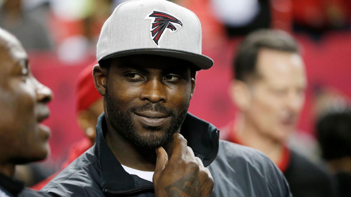 Michael Vick stands on the sidelines before a Jan. 1 game between the Atlanta Falcons and New Orleans Saints in Atlanta.