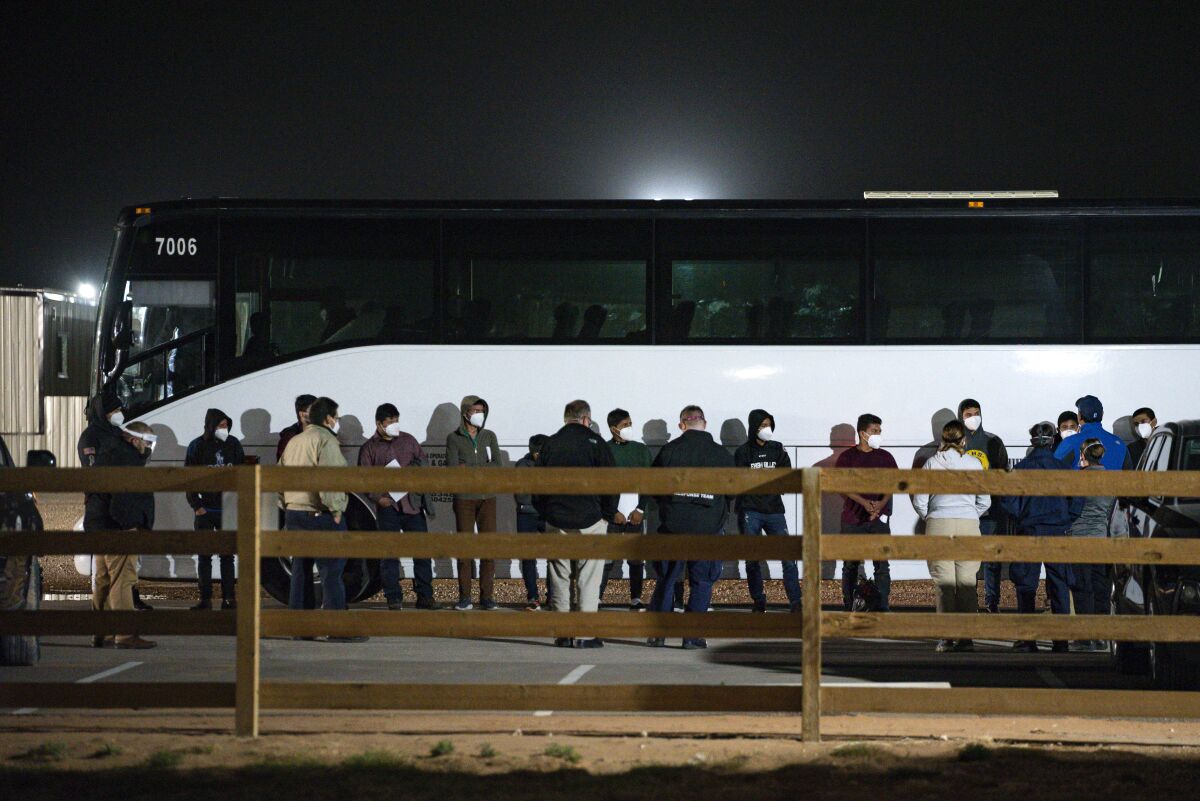 Migrant children and teenagers are processed on March 14, 2021 in front of a bus