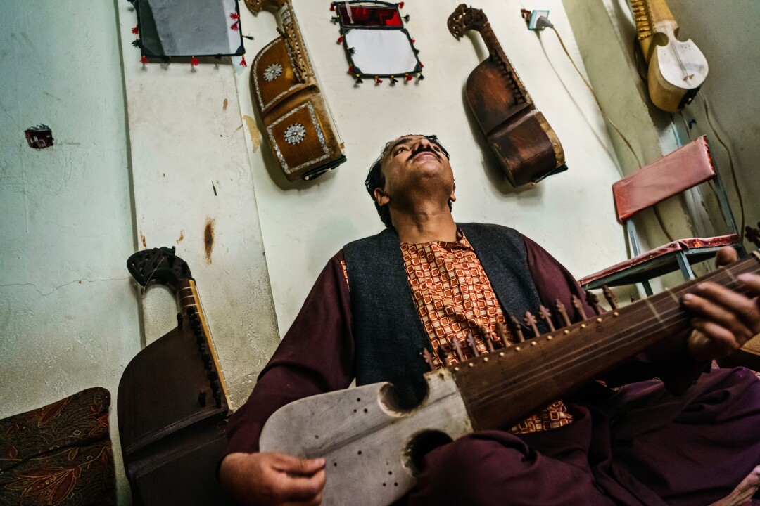 Sheer Agha Mumen Khan practices the rubab in his workshop, in Kabul, Afghanistan.