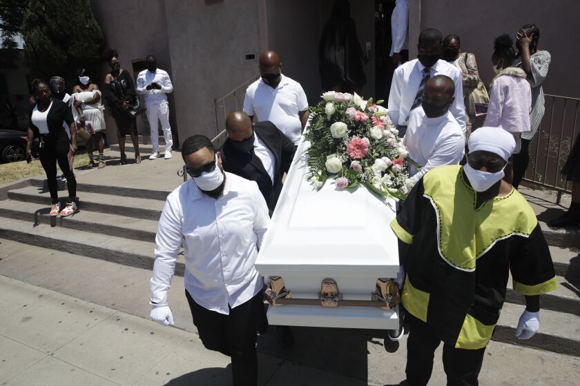 FILE - In this July 21, 2020, file photo, pall bearers carry a casket with the body of Lydia Nunez, who died from COVID-19, after a funeral service at the Metropolitan Baptist Church in Los Angeles. (AP Photo/Marcio Jose Sanchez, File)
