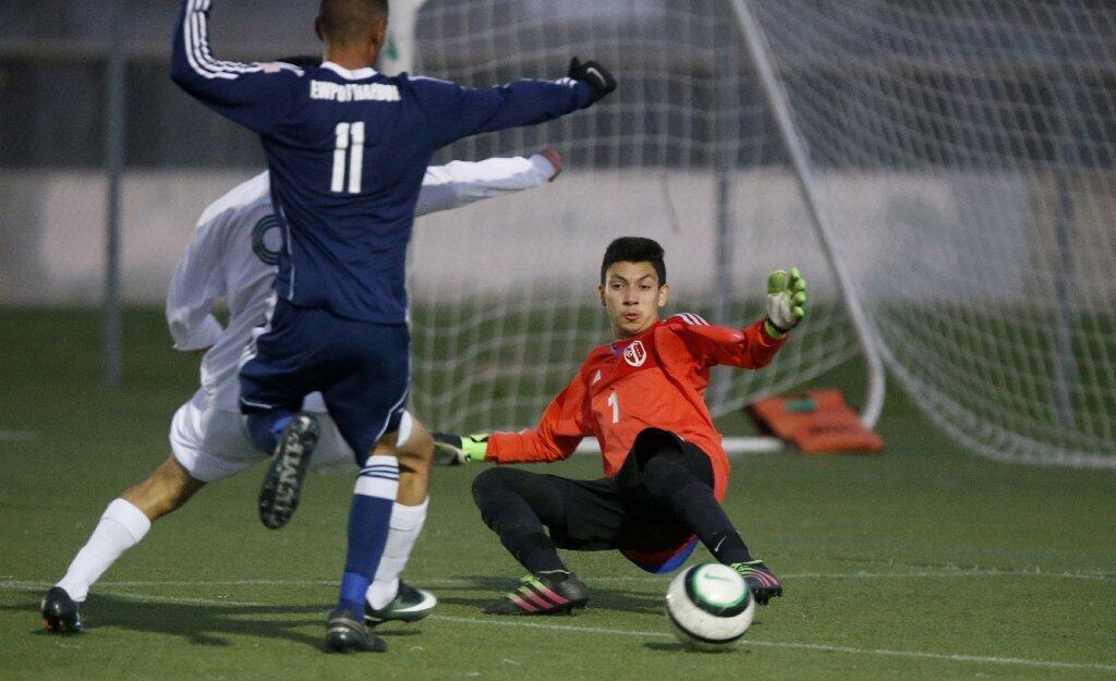 Newport Harbor goalie Damian Ramos stops a ball off Edison as Jonathan Gascon (11) helps defend in the first half.