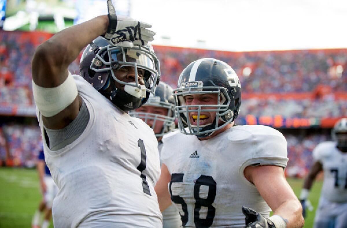 Georgia Southern quarterback Jerick McKinnon celebrates with offensive linesman Garrett Frye after scoring a touchdown against Florida on Saturday at Ben Hill Griffin Stadium.