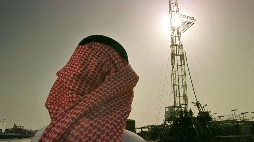 An official of the Saudi oil company Aramco watches progress at a rig at the al-Howta oil field near Howta, Saudi Arabia.