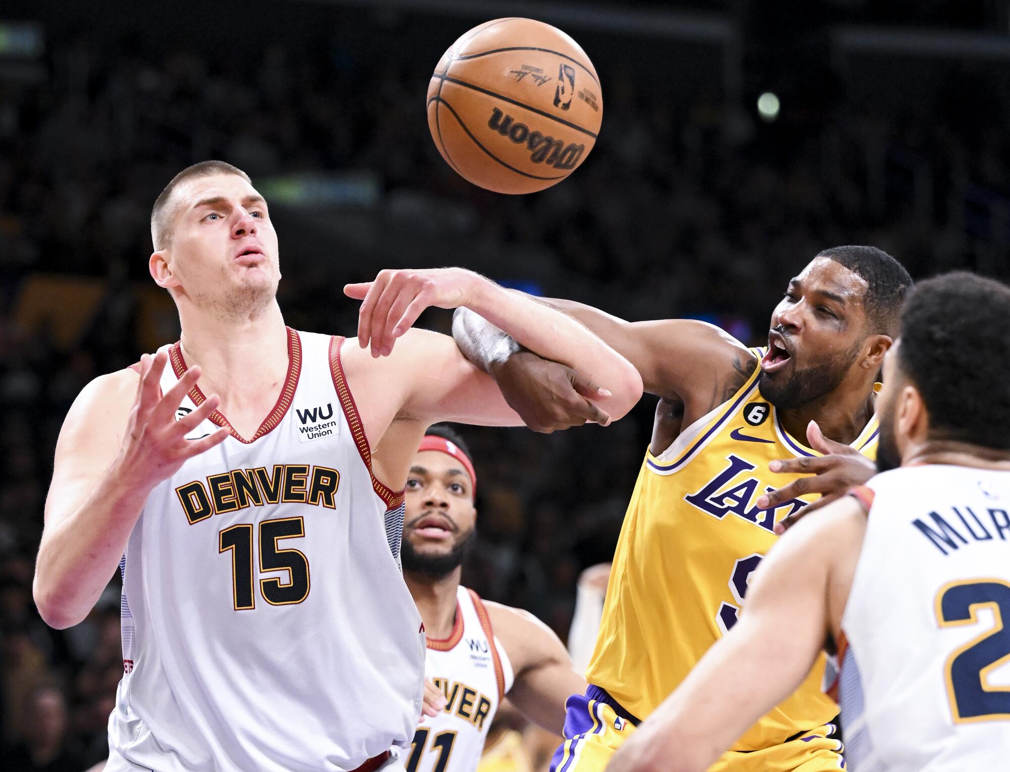 Lakers center Tristan Thompson and Denver Nuggets center Nikola Jokic battle for a rebound.