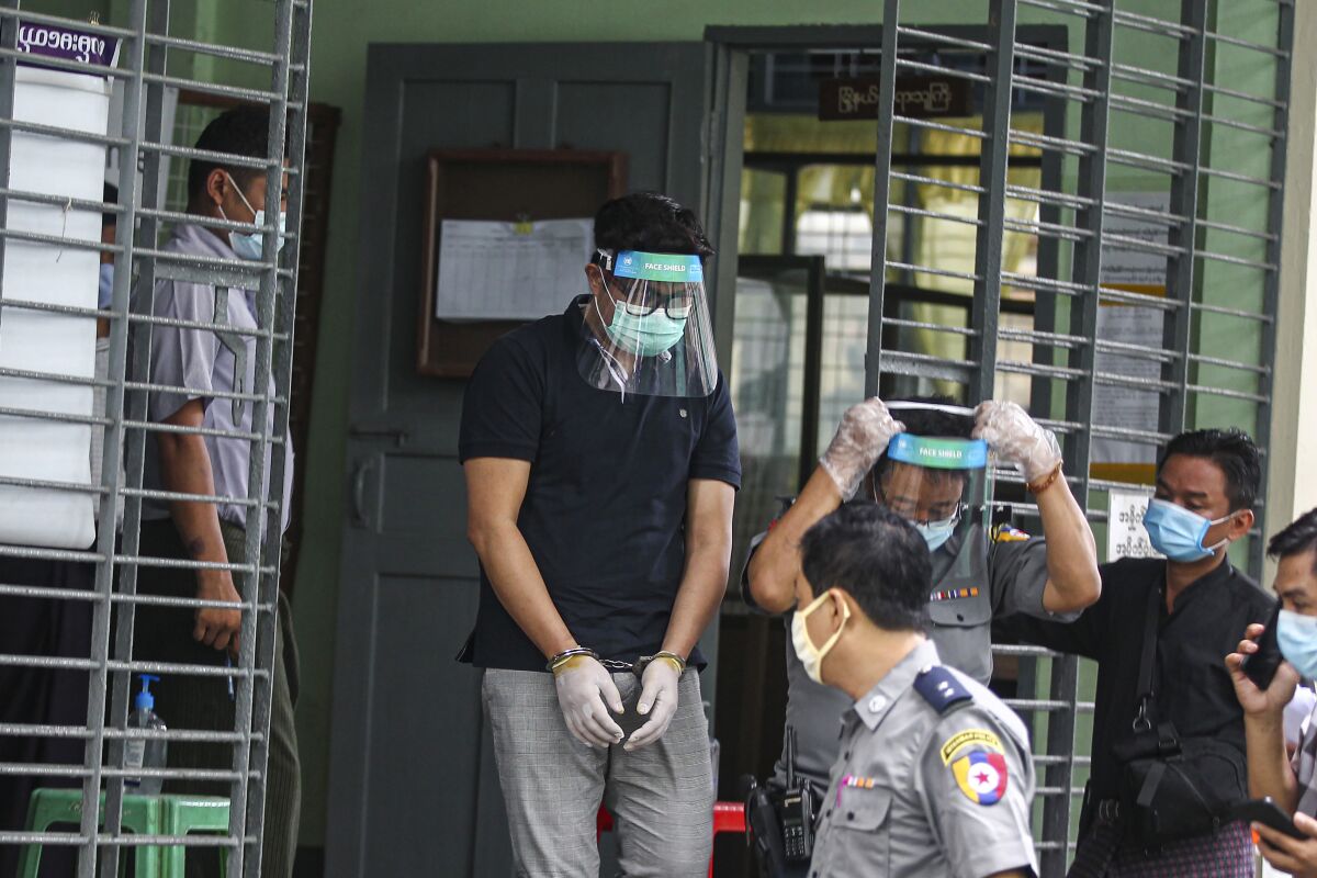 Canadian pastor David Lah covered with face shield and mask is escorted by police men as he leaves from a township court after his first court appearance Wednesday, May 20, 2020, in Yangon, Myanmar. Lah attends a court hearing related to charges filed against him for allegedly organizing public Christian activities in Yangon back in April, after the regional government banned mass gatherings in mid-March to curb the spread of the coronavirus. (AP Photo/Thein Zaw)