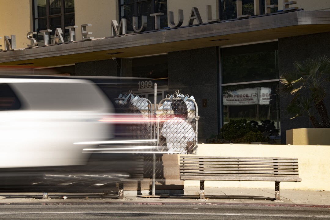 A blurry car passes "Desert Totem Pole (West Adams, California)" and the Golden State Mutual Life Insurance building.