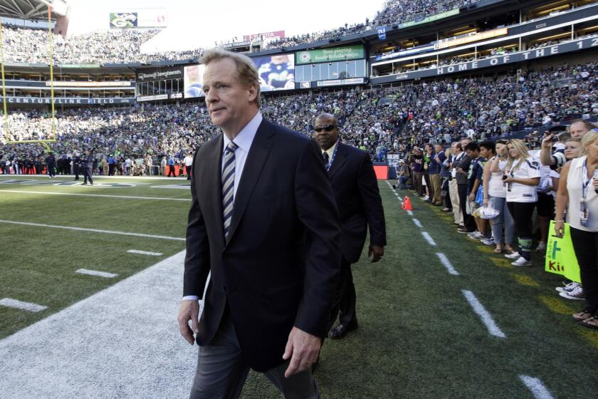NFL Commissioner Roger Goodell walks on the field Thursday before the Packers-Seahawks game. The NFL Players Assn. says the league asked for the right to immediately suspend players who are arrested for allegedly driving under the influence.