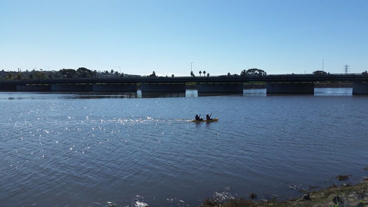 Kayakers paddle back after collecting trash in the estuary area of the San Diego River as part of an annual cleanup event held by the San Diego River Park Foundation.